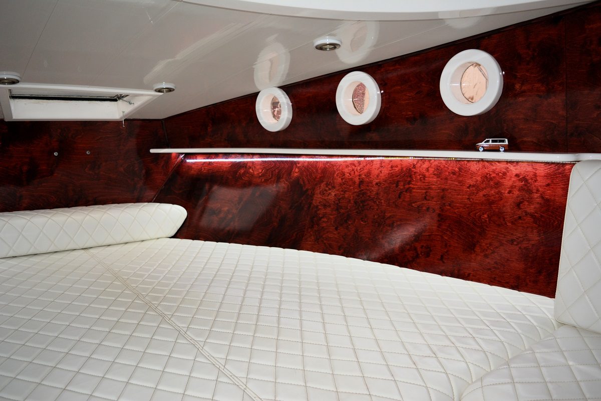 Luxury boat cabin interior with mahogany wood wall and white leather seating