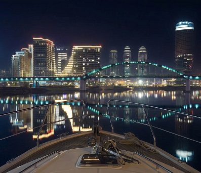 Illuminated Kula Belgrade skyscraper and Belgrade Waterfront viewed from Belgrade River Cruise boat during 2h night cruise