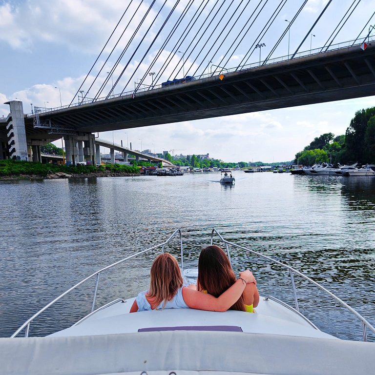 Spacious bow lounge of a private luxury Belgrade River cruising boat on the Sava River with Ada Bridge in Belgrade